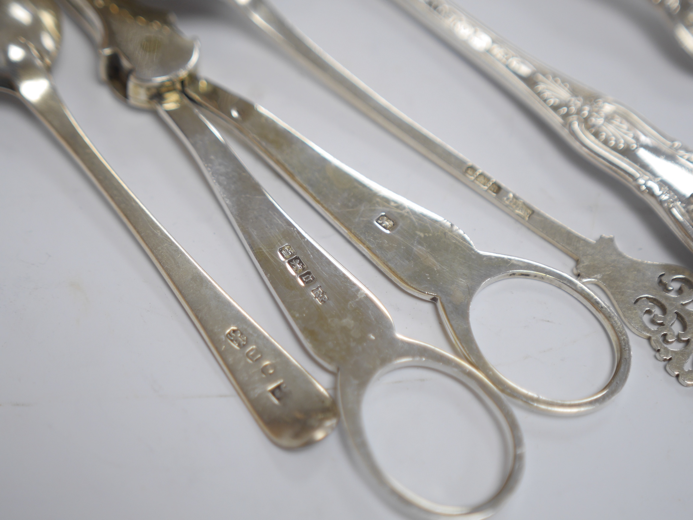 A pair of Edwardian silver grape shears, Sheffield, 1906 and four other items of silver flatware, 9oz. Condition - fair to good